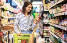 žena s kolicima drži teglu u ruci, nasmiješena