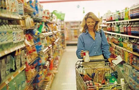 žena s košarom između polica