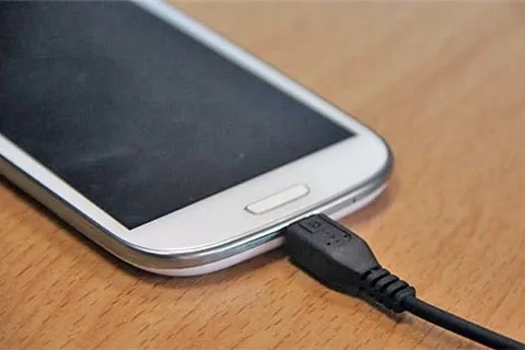 pametni telefon priključen na punjač